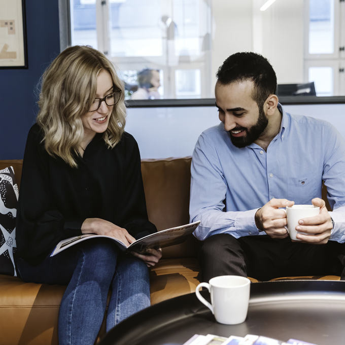 Matilda och Sam diskuterar ett projekt i soffan